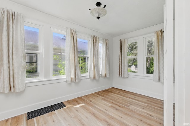 empty room with baseboards and light wood-style floors