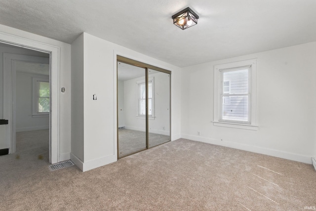 unfurnished bedroom with carpet, multiple windows, and baseboards