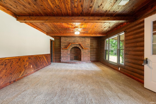 unfurnished living room featuring wood ceiling, beam ceiling, rustic walls, carpet floors, and ceiling fan