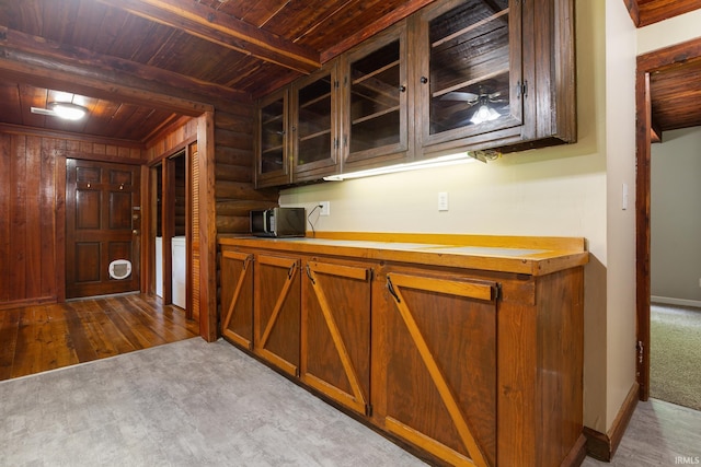 bar area featuring wooden ceiling, beamed ceiling, rustic walls, baseboards, and dark wood-type flooring
