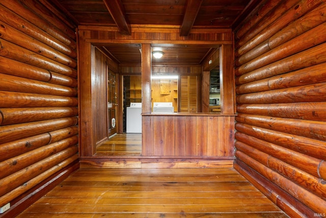 bar area featuring wooden ceiling, beamed ceiling, wood-type flooring, washer and clothes dryer, and wooden walls