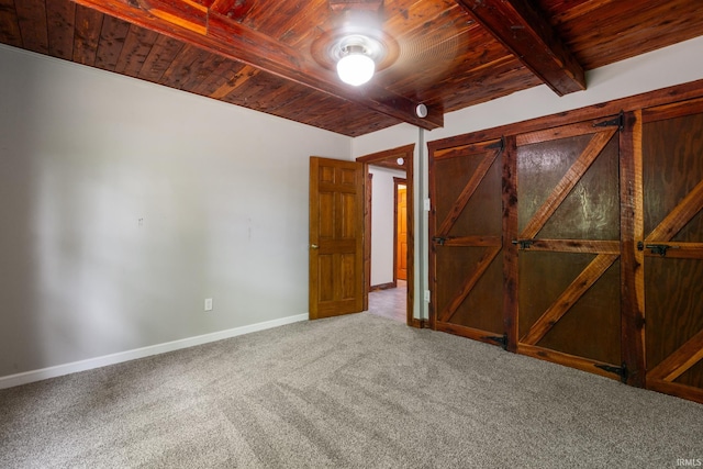 carpeted empty room with wooden ceiling, beamed ceiling, and baseboards