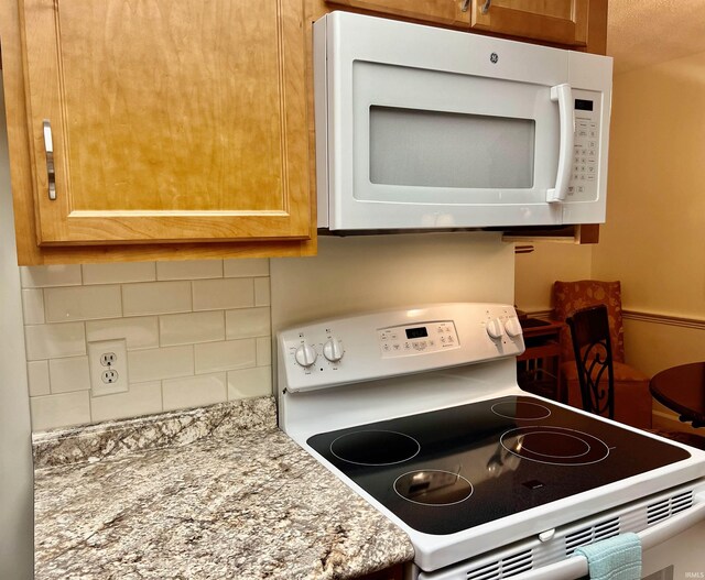 4501 N Wheeling Ave Unit 2-303, Muncie, IN 47304 - kitchen with white appliances, backsplash, and light stone counters