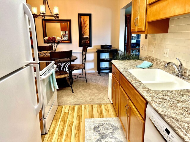 4501 N Wheeling Ave Unit 2-303, Muncie, IN 47304 - kitchen with white appliances, a sink, light wood-style floors, a chandelier, and brown cabinetry