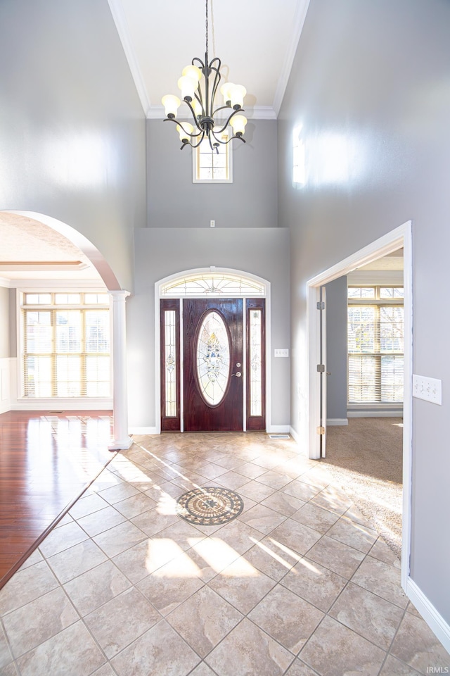 3905 Rushgrove Dr, Lafayette, IN 47909 - entryway with crown molding, arched walkways, a chandelier, a high ceiling, and baseboards