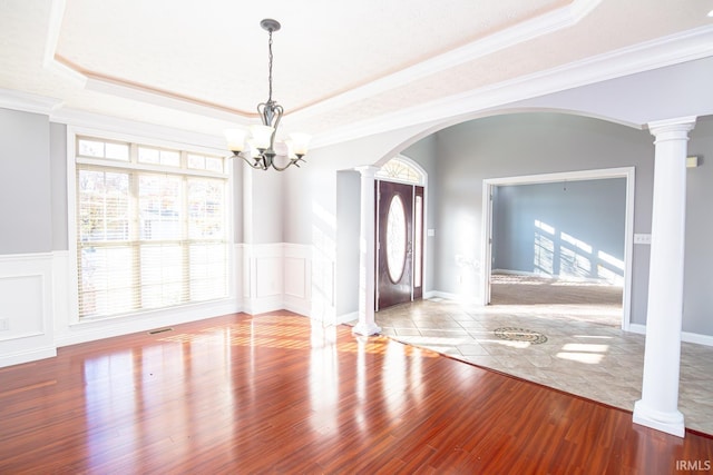 3905 Rushgrove Dr, Lafayette, IN 47909 - spare room featuring arched walkways, decorative columns, healthy amount of natural light, a raised ceiling, and a wainscoted wall