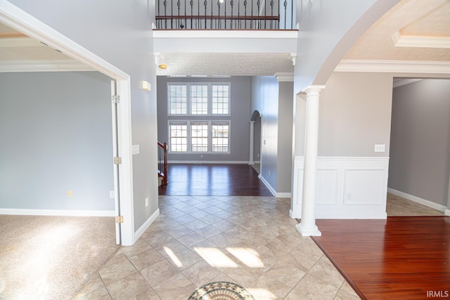 3905 Rushgrove Dr, Lafayette, IN 47909 - foyer featuring decorative columns, crown molding, light wood-type flooring, a high ceiling, and baseboards