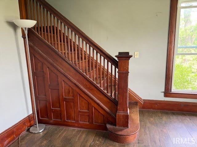 stairway with wood finished floors and baseboards