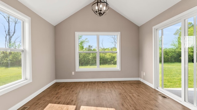 5937 Liam Ln, Fort Wayne, IN 46818 - empty room featuring a chandelier, wood finished floors, baseboards, and vaulted ceiling