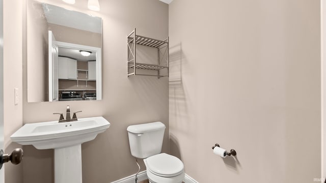 5937 Liam Ln, Fort Wayne, IN 46818 - half bath featuring toilet, baseboards, and a sink