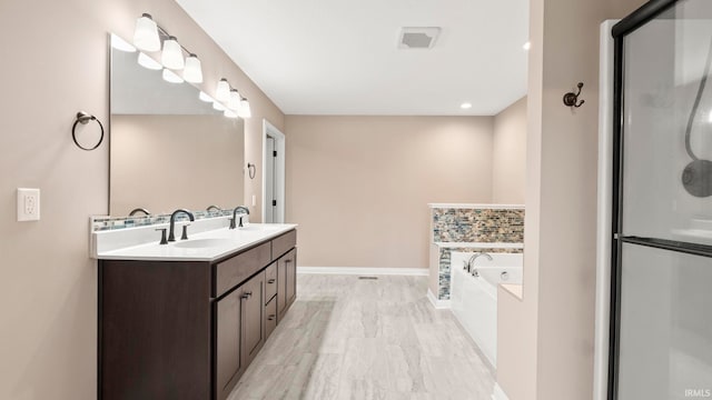 5937 Liam Ln, Fort Wayne, IN 46818 - full bathroom featuring double vanity, a garden tub, baseboards, and a shower with shower door