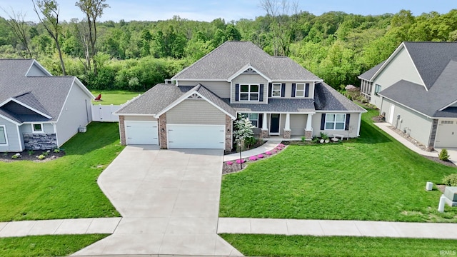 5937 Liam Ln, Fort Wayne, IN 46818 - craftsman house with driveway, a garage, a wooded view, and a porch