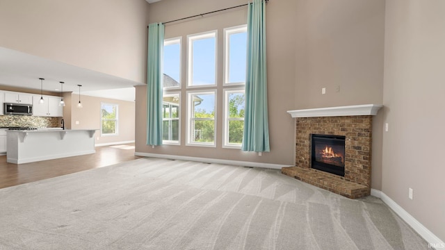5937 Liam Ln, Fort Wayne, IN 46818 - unfurnished living room with a high ceiling, light colored carpet, baseboards, and a fireplace