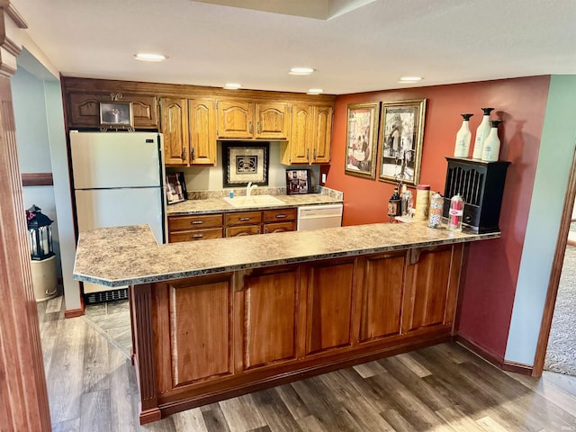16529 State Road 1st Rd, Spencerville, IN 46788 - kitchen with white appliances, dark wood-style flooring, brown cabinetry, a sink, and a peninsula