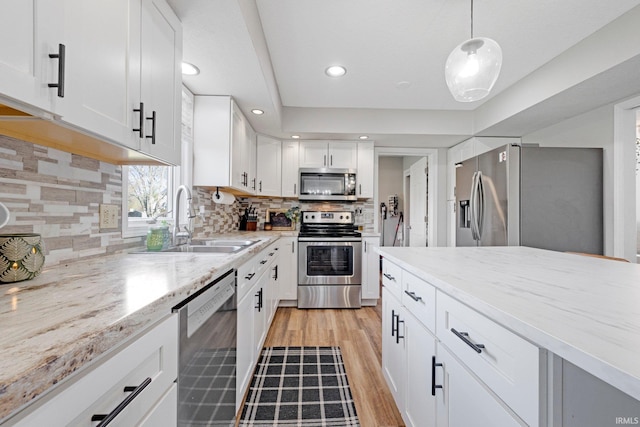 10731 Willow Creek Dr, Fort Wayne, IN 46845 - kitchen with appliances with stainless steel finishes, a sink, light wood finished floors, white cabinets, and recessed lighting