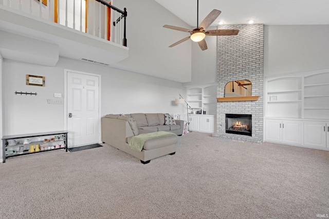 10731 Willow Creek Dr, Fort Wayne, IN 46845 - carpeted living room featuring high vaulted ceiling, ceiling fan, a fireplace, and built in shelves