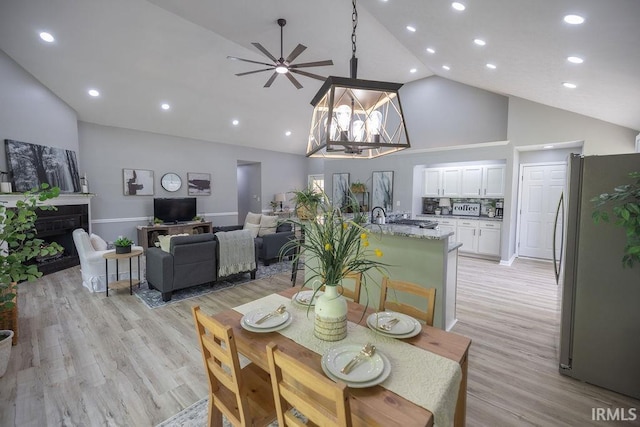 103 Bluebird Ln, Sulphur Springs, IN 47388 - dining area featuring high vaulted ceiling, ceiling fan, light wood-type flooring, a fireplace, and recessed lighting