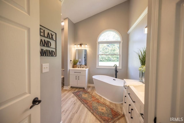 103 Bluebird Ln, Sulphur Springs, IN 47388 - full bathroom with wood finished floors, a soaking tub, vanity, and baseboards