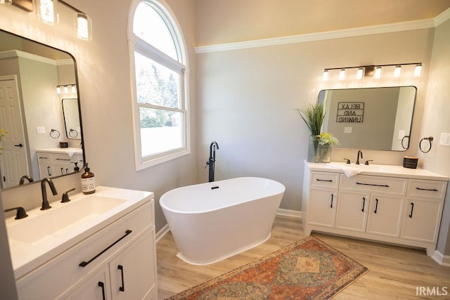 103 Bluebird Ln, Sulphur Springs, IN 47388 - full bath featuring wood finished floors, two vanities, a freestanding bath, and baseboards