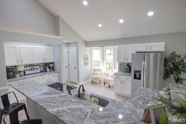 103 Bluebird Ln, Sulphur Springs, IN 47388 - kitchen featuring stainless steel fridge with ice dispenser, white cabinets, a sink, light wood-style flooring, and light stone counters