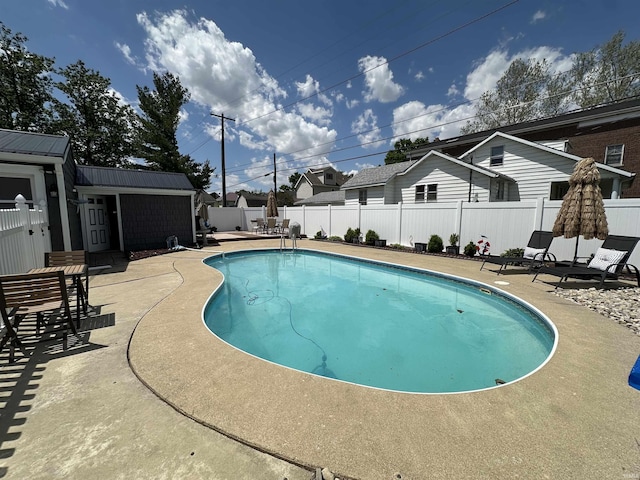 134 E 3rd St, Peru, IN 46970 - view of swimming pool with a patio area, a fenced backyard, and an outbuilding