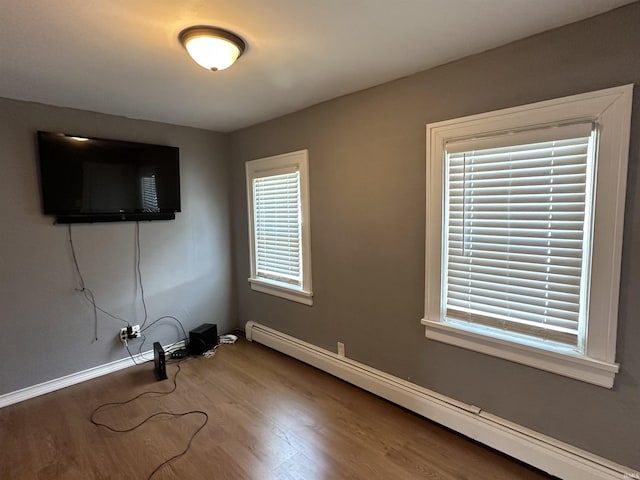 134 E 3rd St, Peru, IN 46970 - empty room featuring a baseboard heating unit, wood finished floors, and baseboards