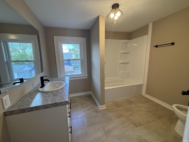 bathroom with baseboards, plenty of natural light, vanity, and washtub / shower combination