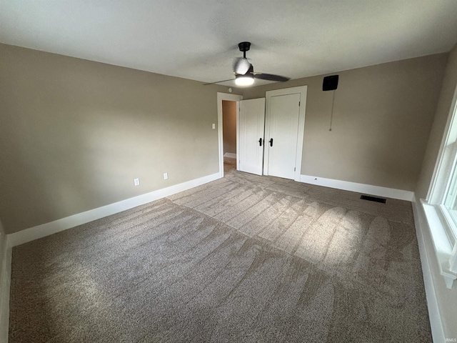 unfurnished bedroom with carpet, baseboards, a ceiling fan, and a closet