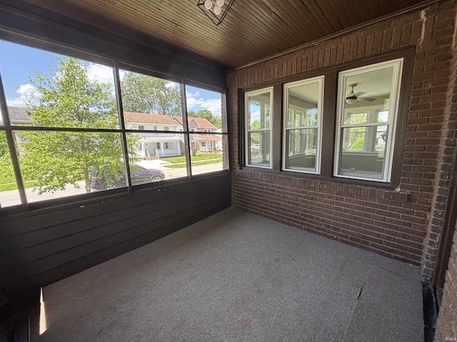 unfurnished sunroom featuring a ceiling fan