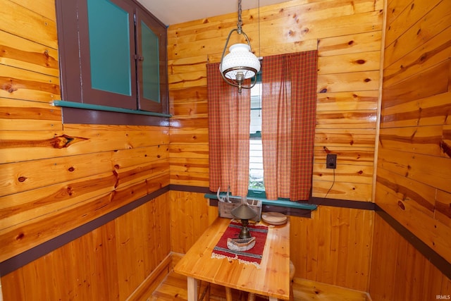 unfurnished dining area featuring wood walls