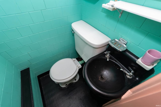 half bathroom with tile walls and toilet