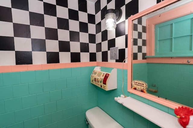 half bathroom featuring tile walls and toilet