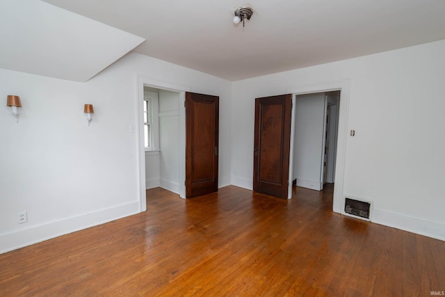 unfurnished bedroom with wood finished floors and baseboards