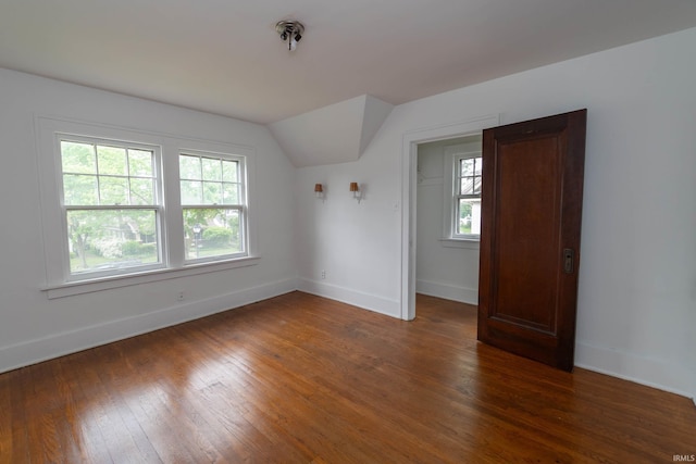 spare room with healthy amount of natural light, baseboards, and lofted ceiling