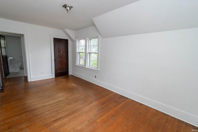 additional living space featuring baseboards and wood finished floors