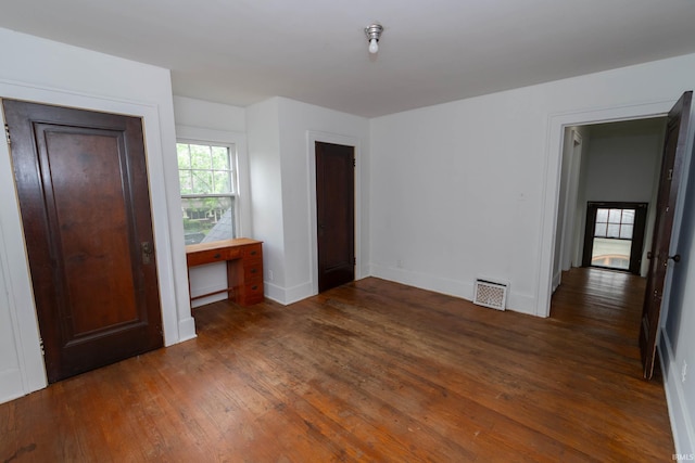 unfurnished bedroom with hardwood / wood-style flooring and baseboards