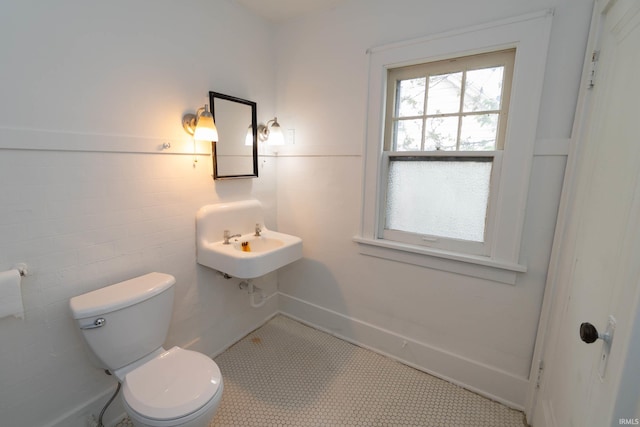 bathroom featuring toilet and wainscoting