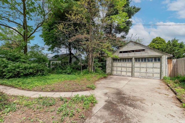 exterior space with a garage, an outbuilding, and fence