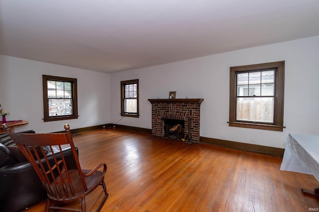 living room with light wood-type flooring, plenty of natural light, and baseboards