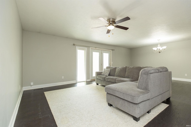 living area with dark wood-style floors, baseboards, a ceiling fan, and a chandelier