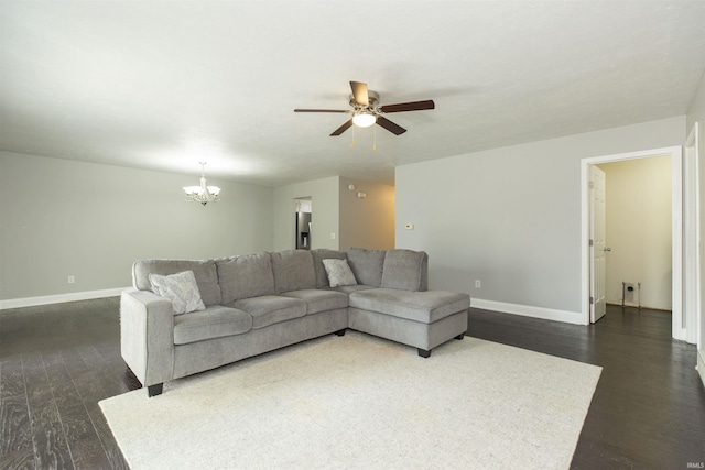 living room with dark wood finished floors, baseboards, a chandelier, and a ceiling fan