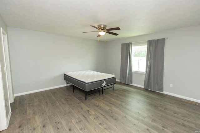 bedroom featuring wood finished floors, baseboards, and ceiling fan
