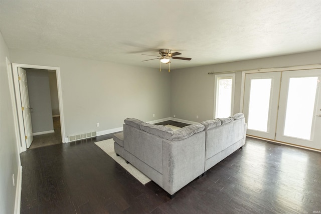living room featuring ceiling fan, dark wood-style floors, and baseboards