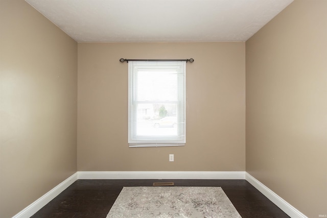 empty room with dark wood-style floors and baseboards