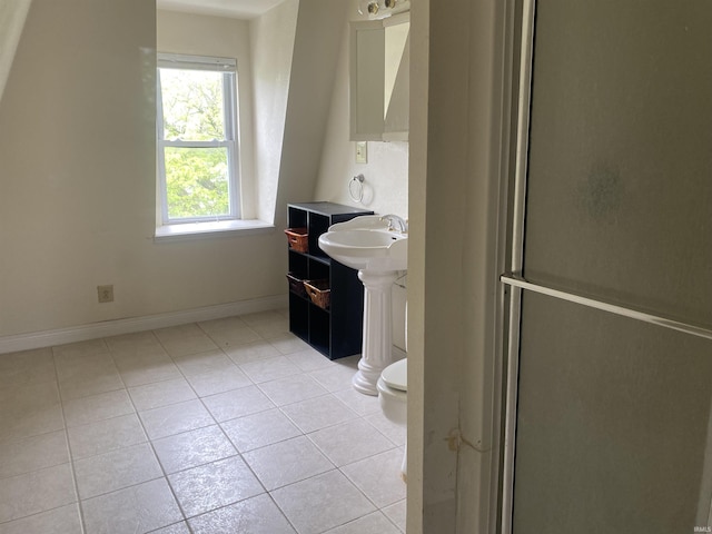 bathroom featuring tile patterned flooring, toilet, a sink, and baseboards