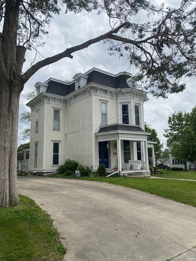 606 E Walnut St, Portland, IN 47371 - second empire-style home with mansard roof, covered porch, a shingled roof, and a front lawn