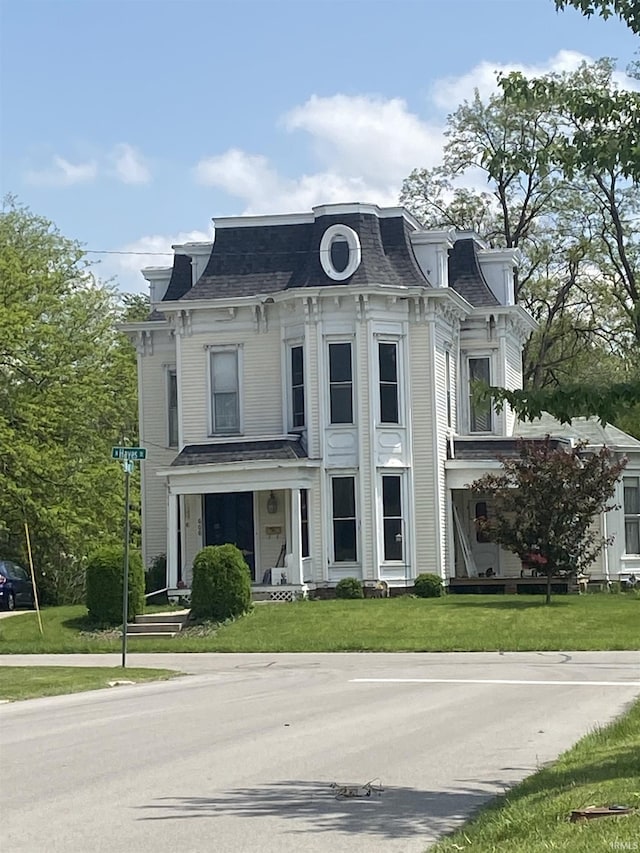 606 E Walnut St, Portland, IN 47371 - second empire-style home featuring mansard roof, a front lawn, a porch, and a shingled roof