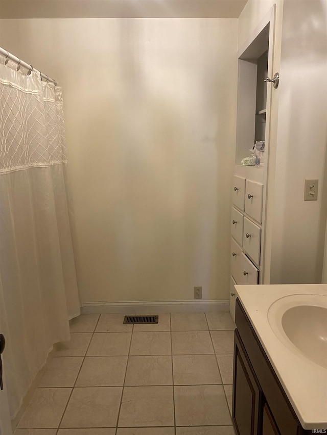 bathroom featuring tile patterned flooring, vanity, baseboards, and a shower with shower curtain