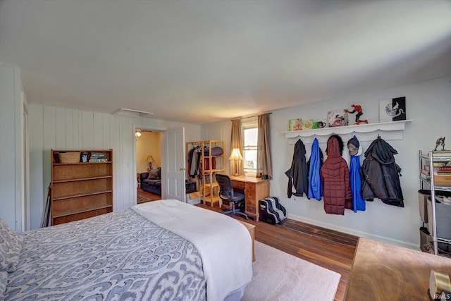 bedroom with wood finished floors, baseboards, and a desk