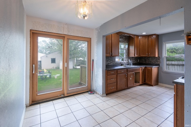 kitchen featuring dark countertops, healthy amount of natural light, tasteful backsplash, and a sink